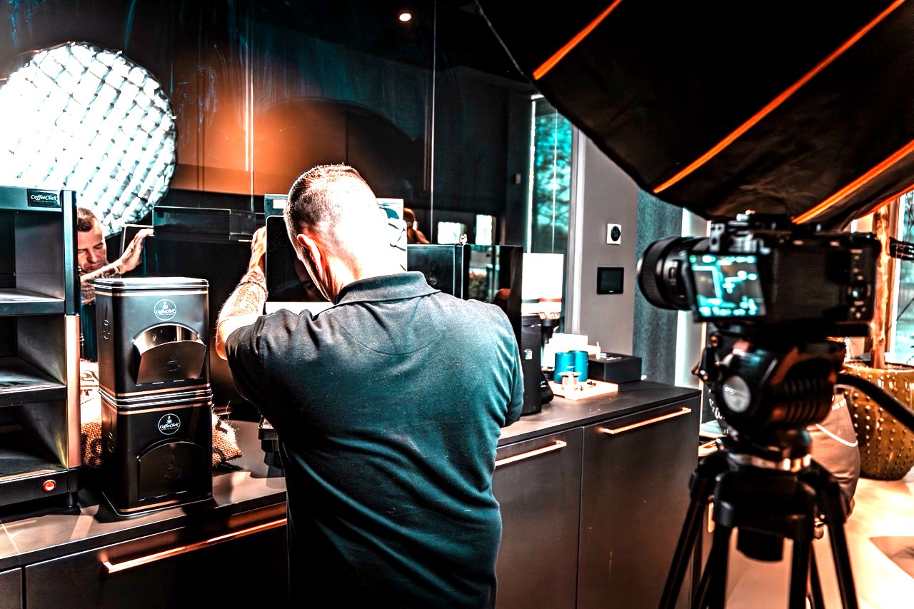 Camera op statief tijdens een opname op locatie in een koffiezaak